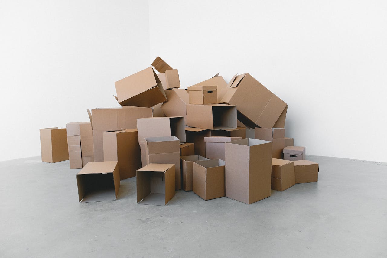 about-02 Pile of cardboard containers prepared for relocation on floor at home in daylight on white background