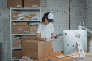 Custom Packaging for Online Stores in Faisalabad and Across Pakistan Woman managing shipping logistics for her small business, ensuring accurate inventory and order fulfillment.